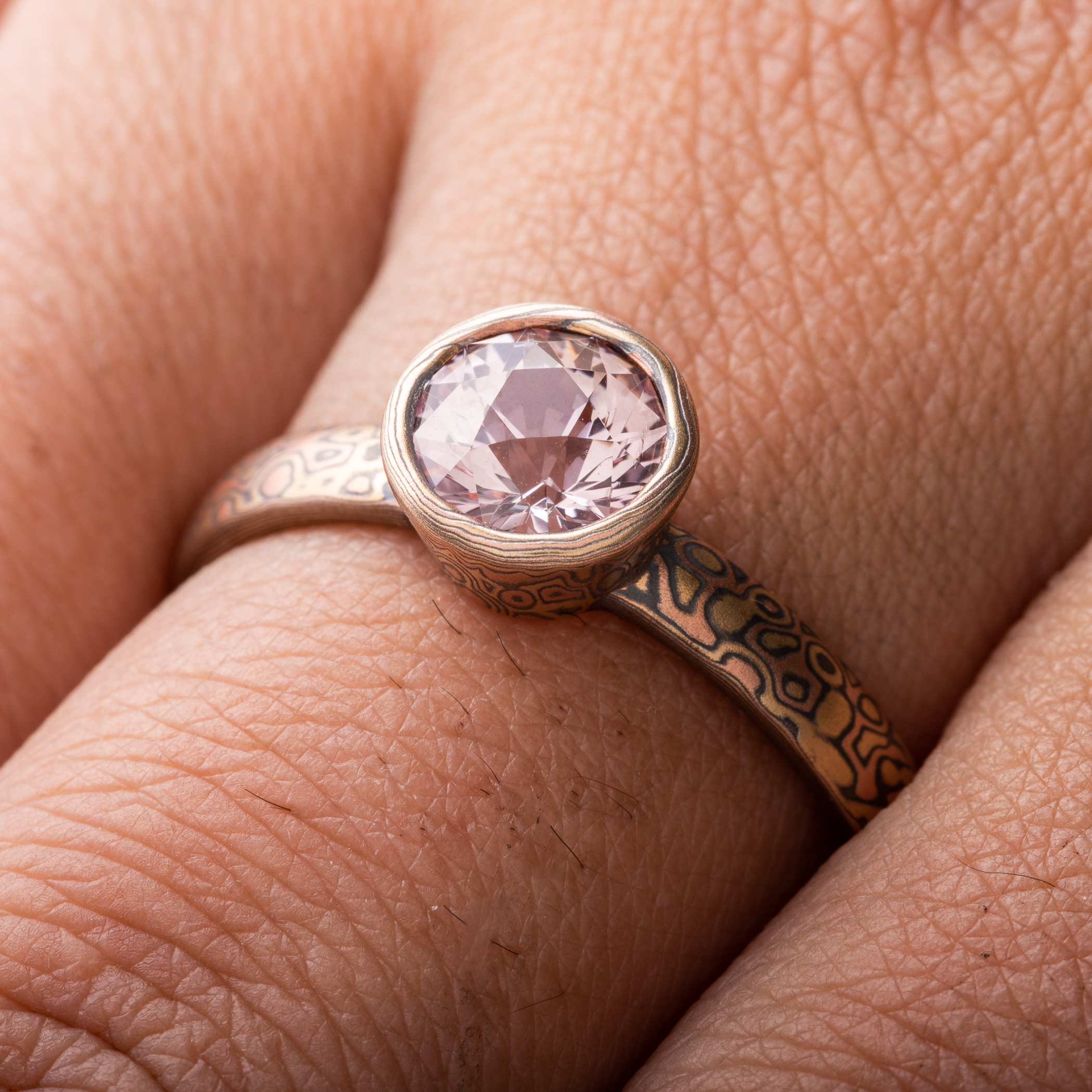 Mokume Gane ring or engagement ring arn krebs, pink sapphire in a mokume bezel, droplet pattern and fire palette, yellow gold red gold and silver