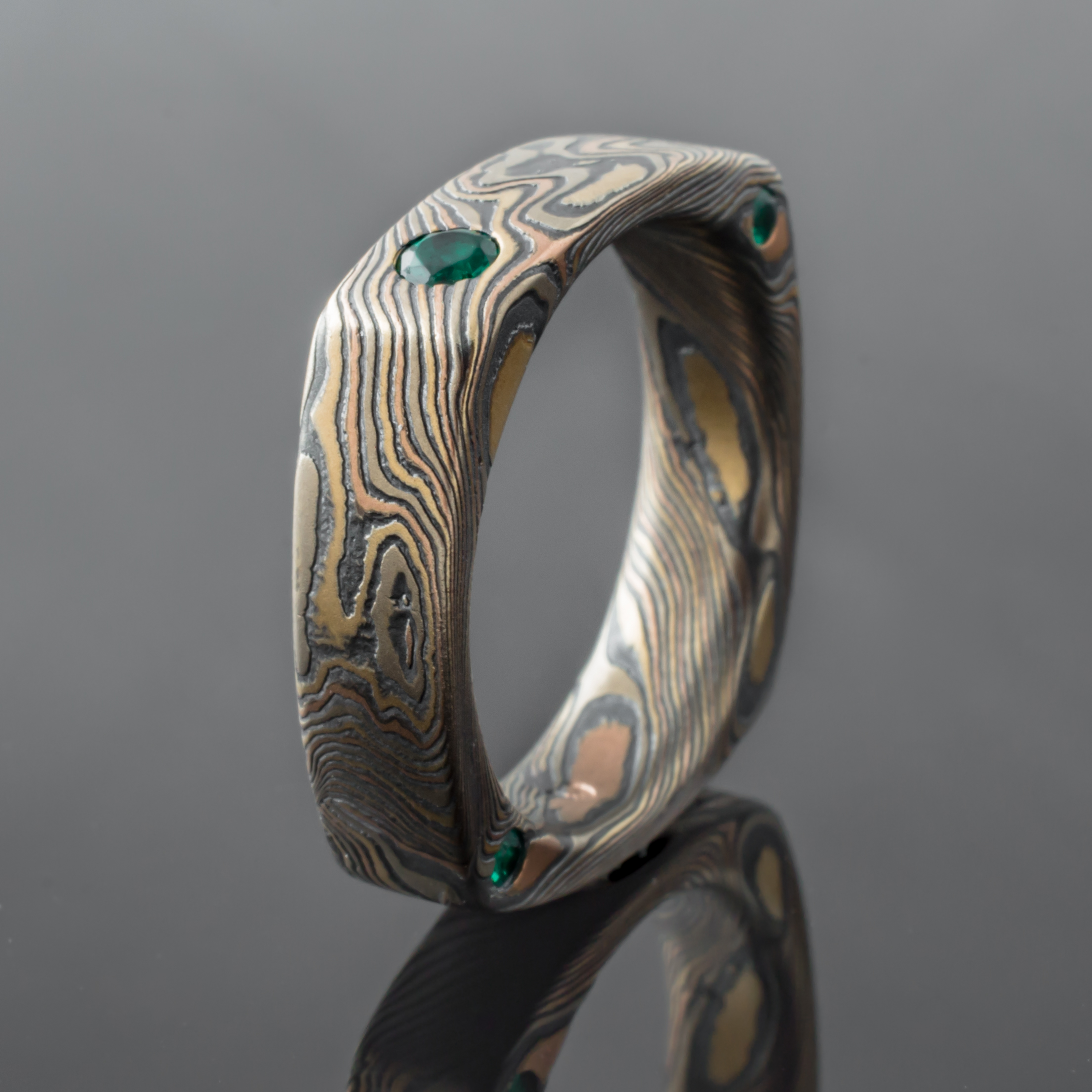 Mokume Square Ring Mens Wedding Band with round, flush set emerald. Artisan, nature inspired, handcrafted, organic, contemporary style.