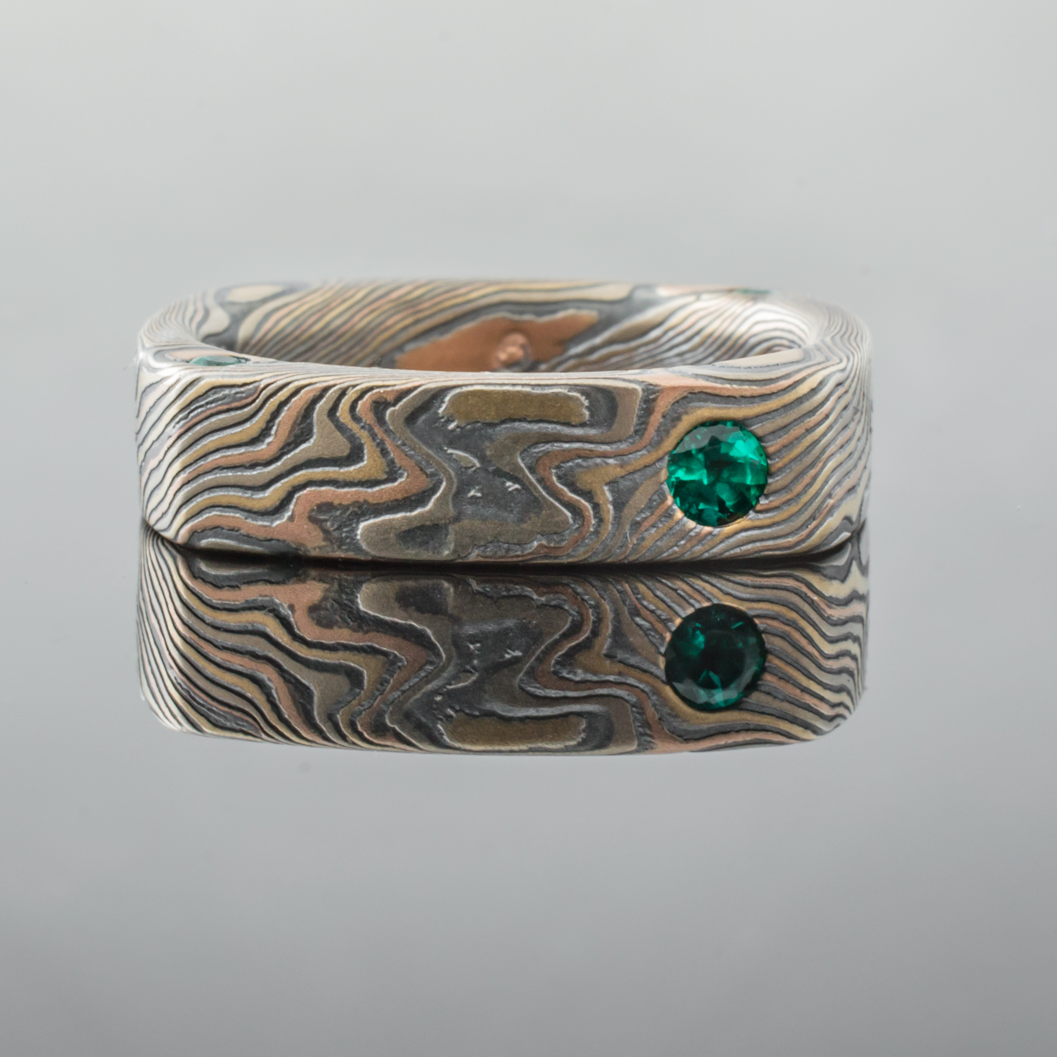 Mokume Square Ring Mens Wedding Band with round, flush set emerald. Artisan, nature inspired, handcrafted, organic, contemporary style.