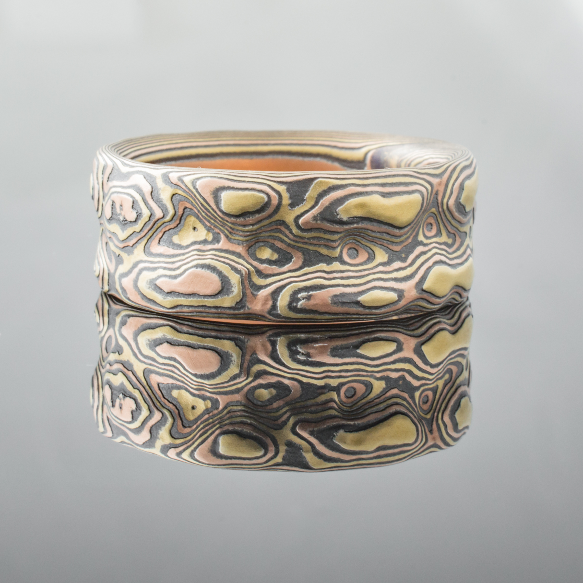 Textured mokume gane ring with red and yellow gold and oxidized silver. Arn Krebs Guri Bori