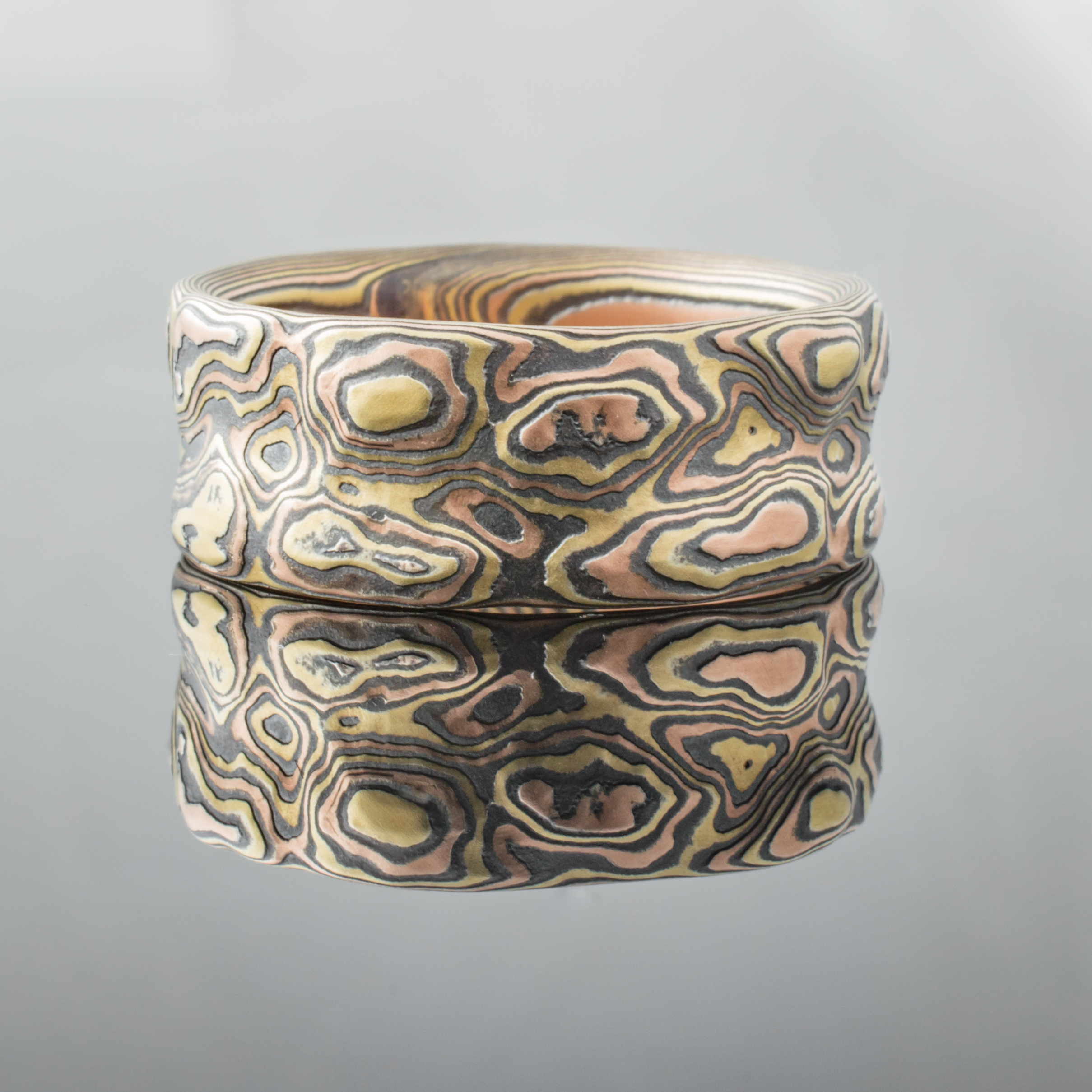 Textured mokume gane ring with red and yellow gold and oxidized silver. Arn Krebs Guri Bori