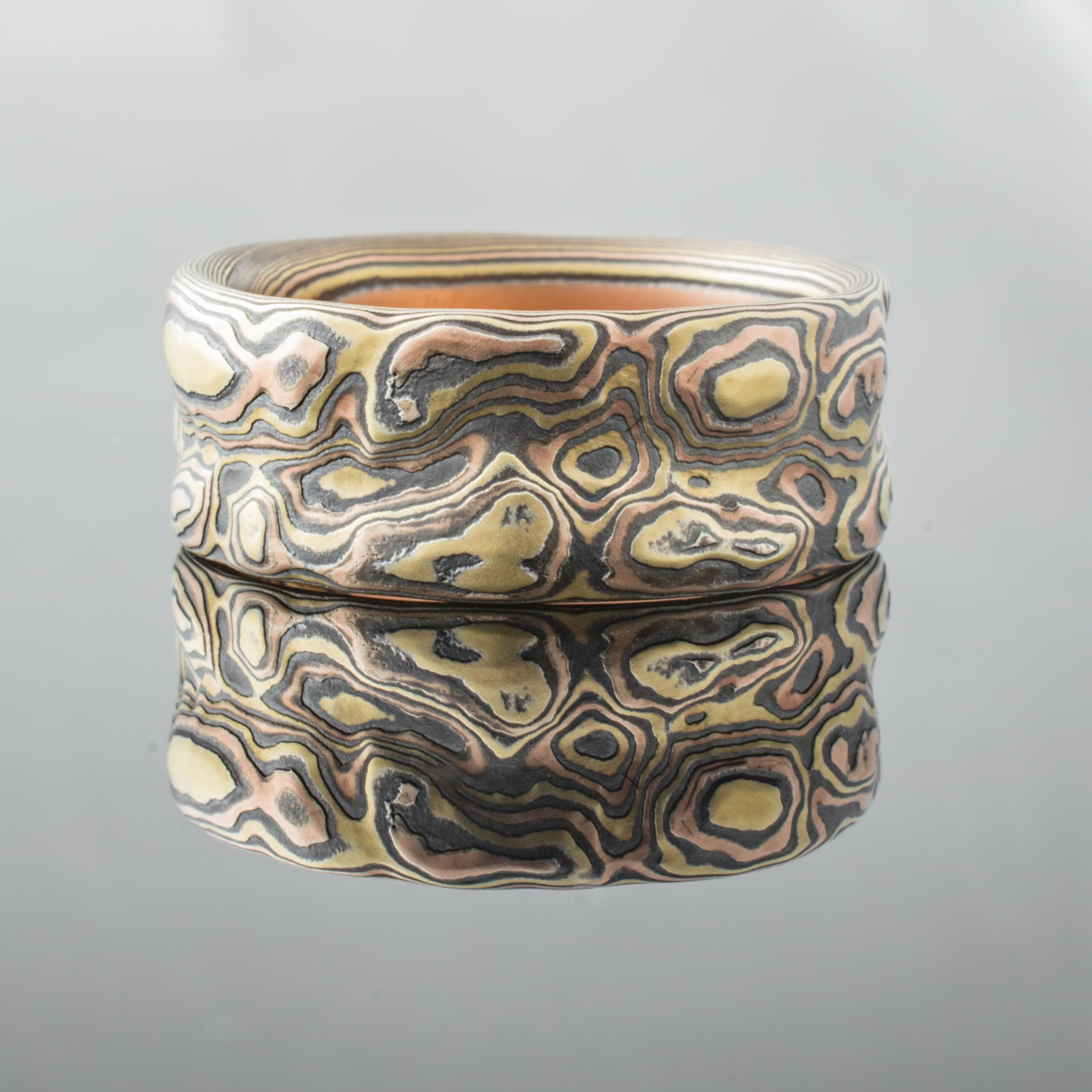Textured mokume gane ring with red and yellow gold and oxidized silver. Arn Krebs Guri Bori