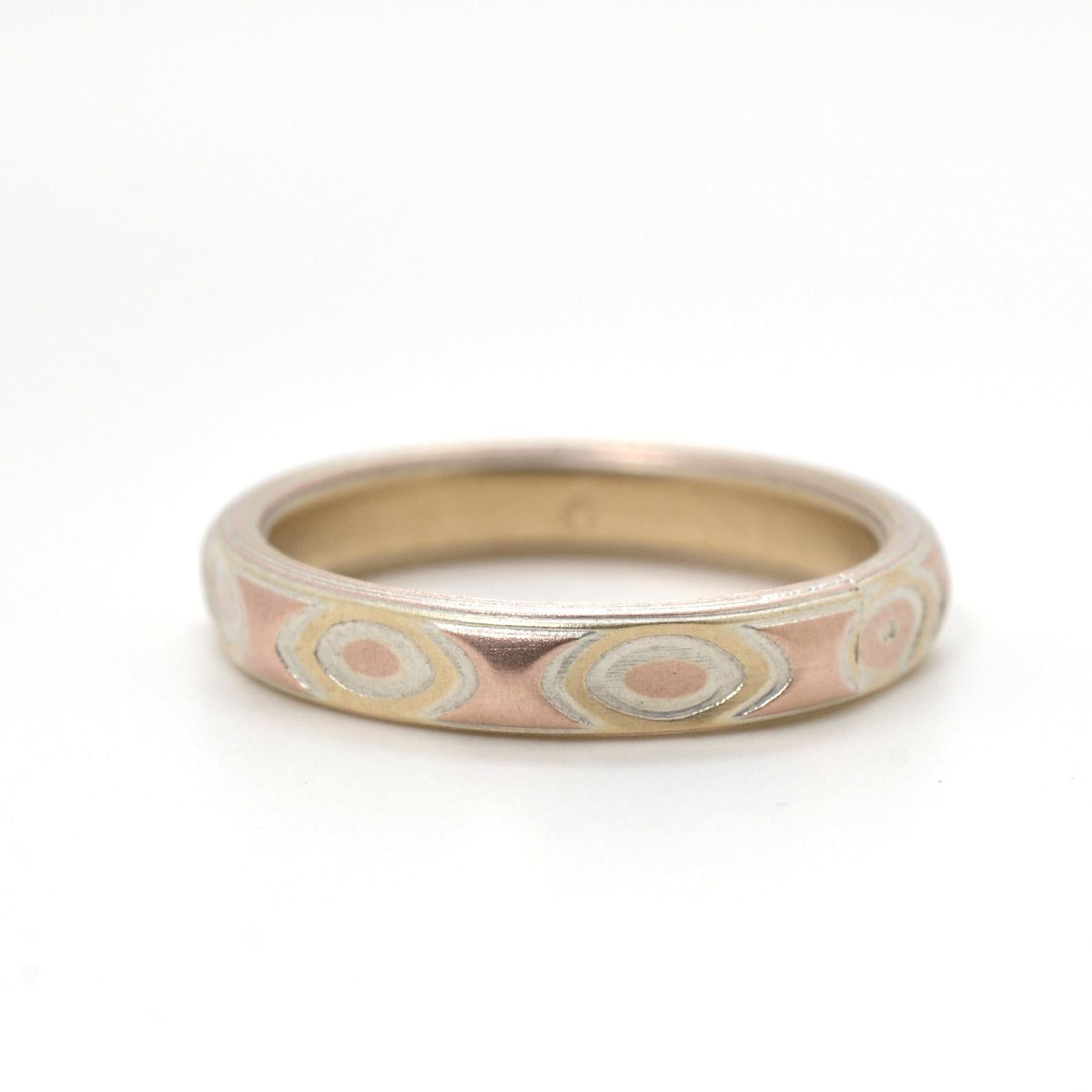 Mokume gane ring patterned with faceted droplets, made with red and yellow gold.