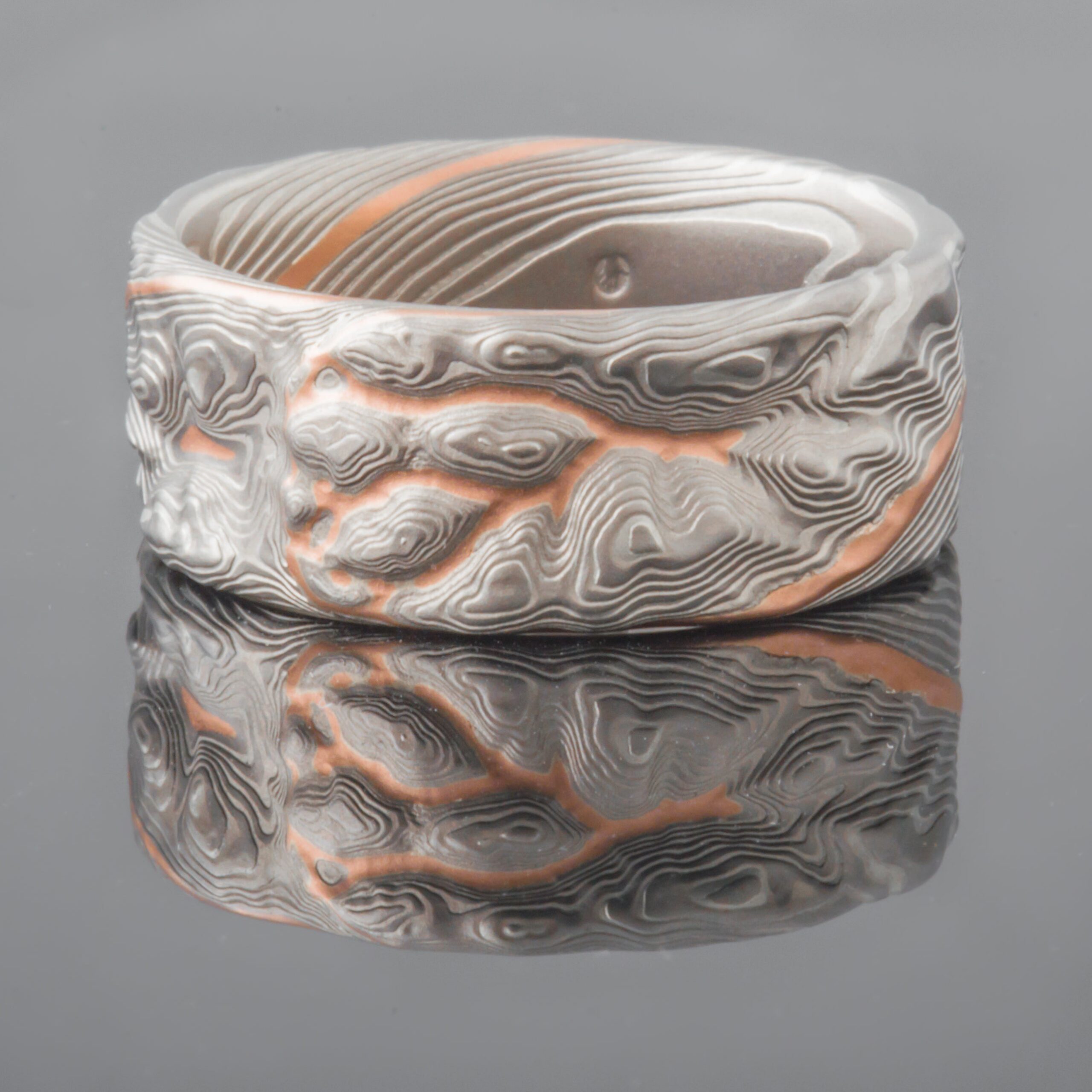 Textured mokume gane patterned ring, resembling stone. With veins of red gold throughout.