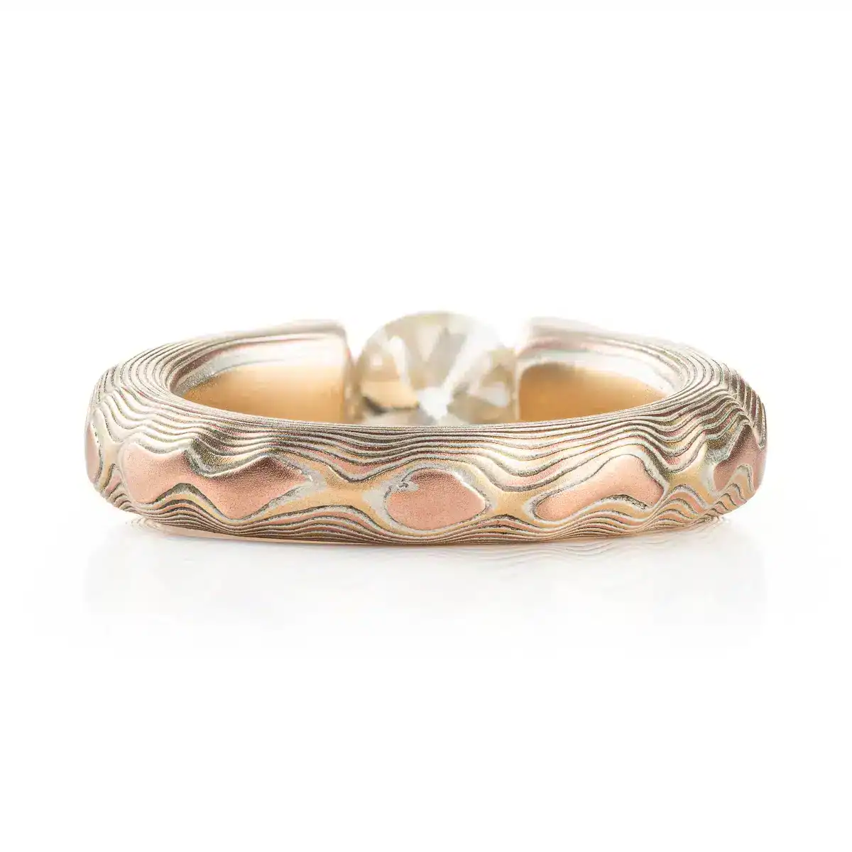 mokume gane tension set ring with diamond in guri bori pattern and gold and silver
