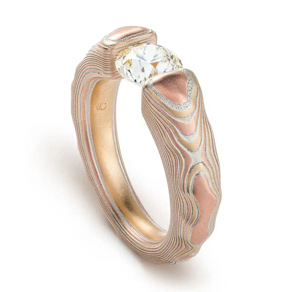 mokume gane tension set ring with diamond in guri bori pattern and gold and silver