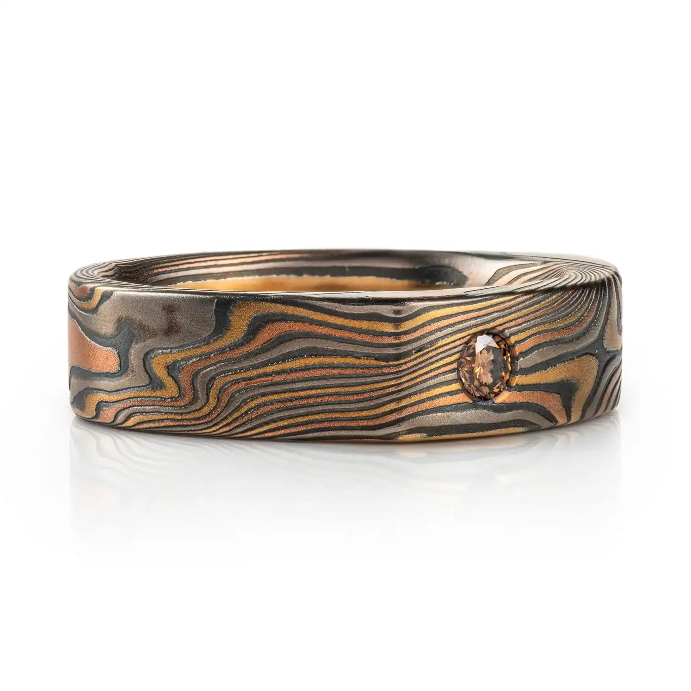 uniquely profiled soft square shaped mokume gane ring with a thicker top section - somewhat similar to a signet style ring, but rectangular, with a small cognac diamond flush set into a corner