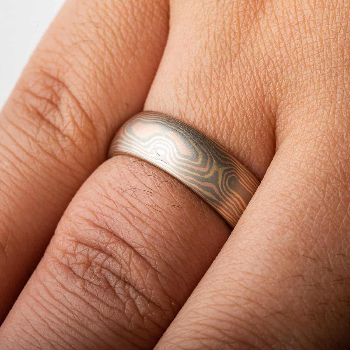 Rustic and elegant Mokume Gane band with woodgrain pattern and Cinders metal combination in low dome and satin finish.