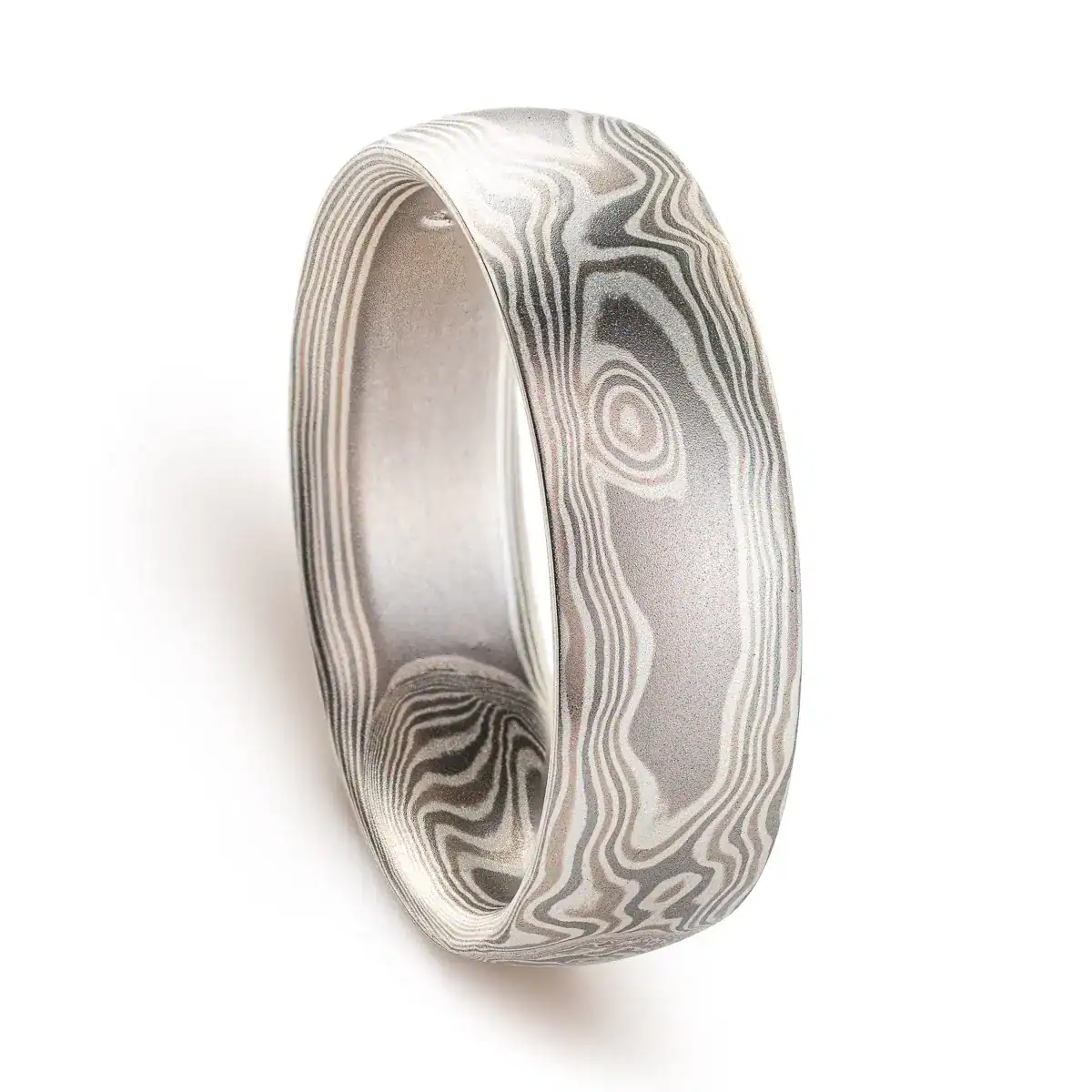 mokume gane band patterned to resemble woodgrain, in a silver looking palette with metals of different shades