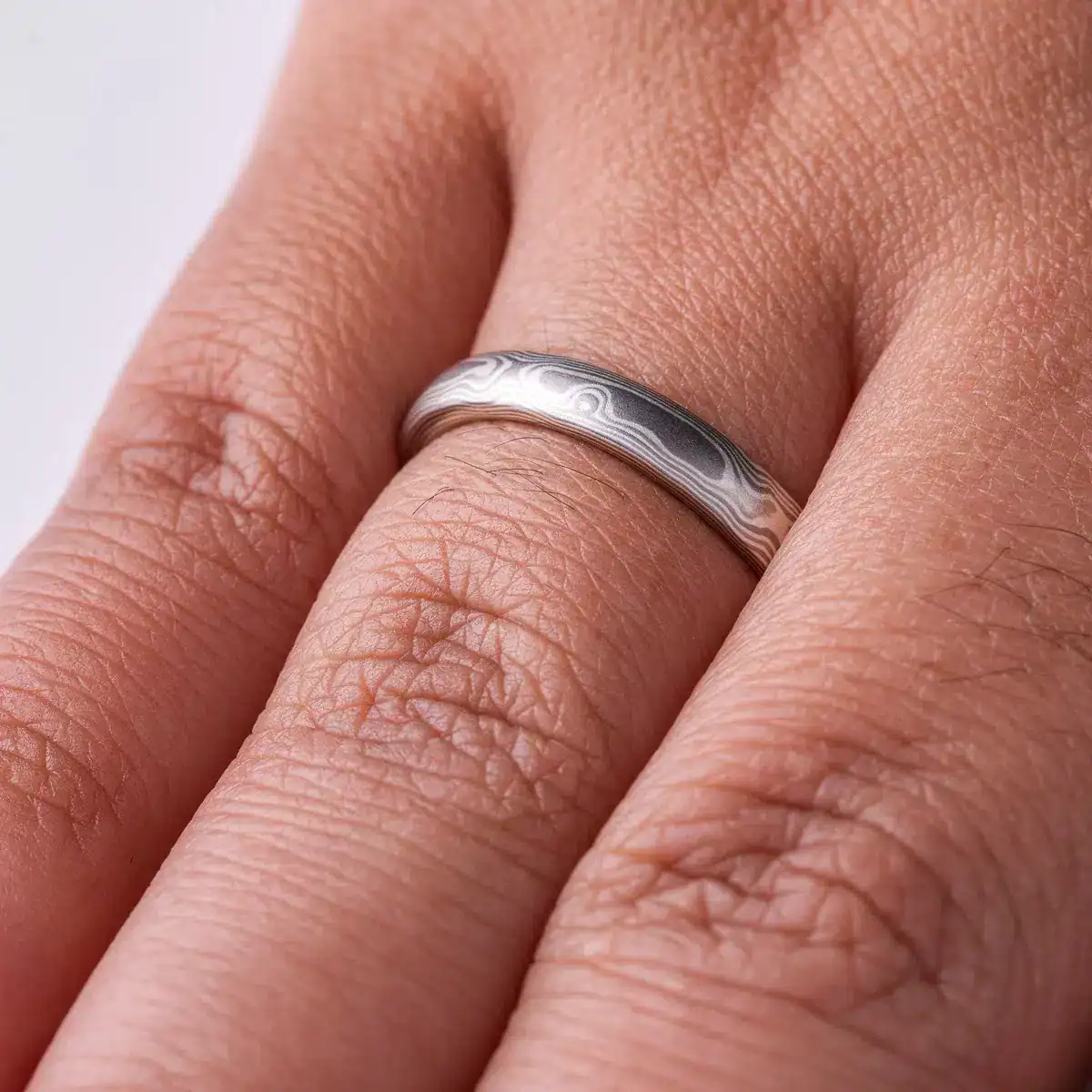 mokume gane band patterned to resemble woodgrain, in a silver looking palette with metals of different shades
