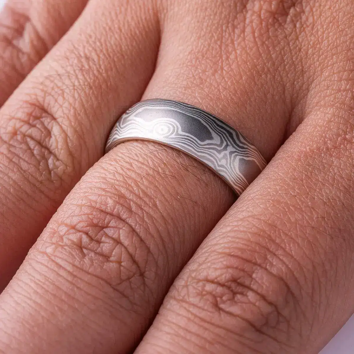 mokume gane band patterned to resemble woodgrain, in a silver looking palette with metals of different shades