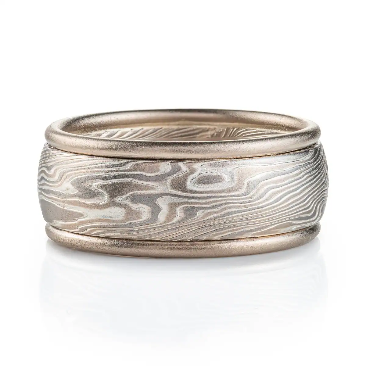 mokume gane twisted pattern ring made of layers of metal in different shades of gray, the ring also has added rails running around the top and bottom edges