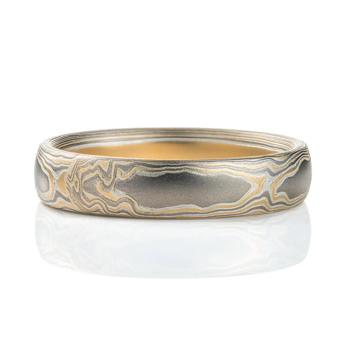 Slightly domed woodgrain mokume gane band made with yellow gold, palladium (dark gray) and silver (light gray).