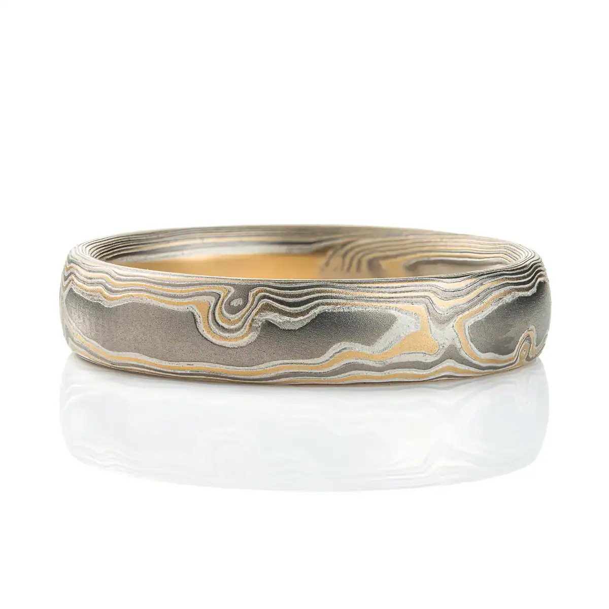 Slightly domed woodgrain mokume gane band made with yellow gold, palladium (dark gray) and silver (light gray).