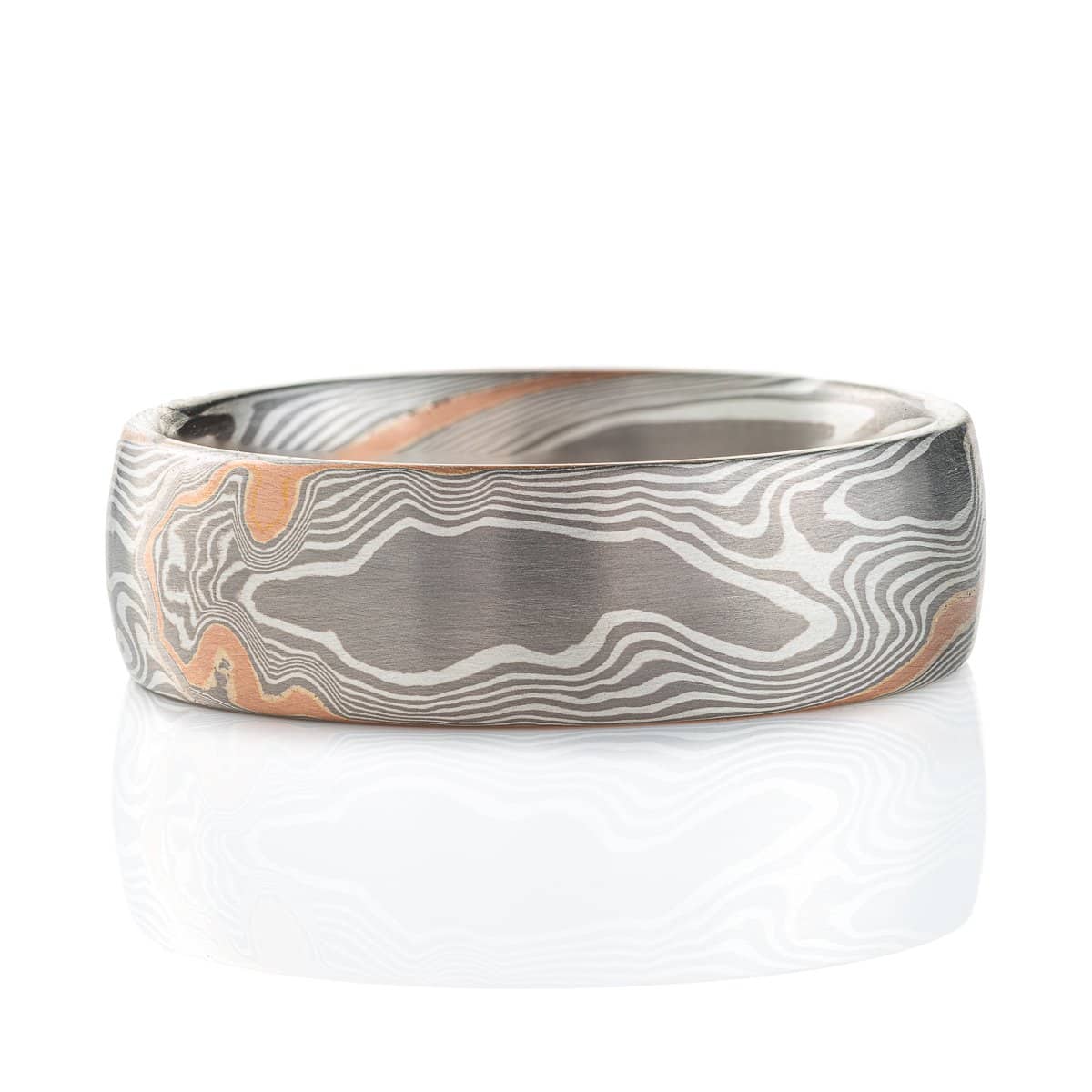 Silvery mokume gane ring made in twisting pattern, with one streak of red gold running through.