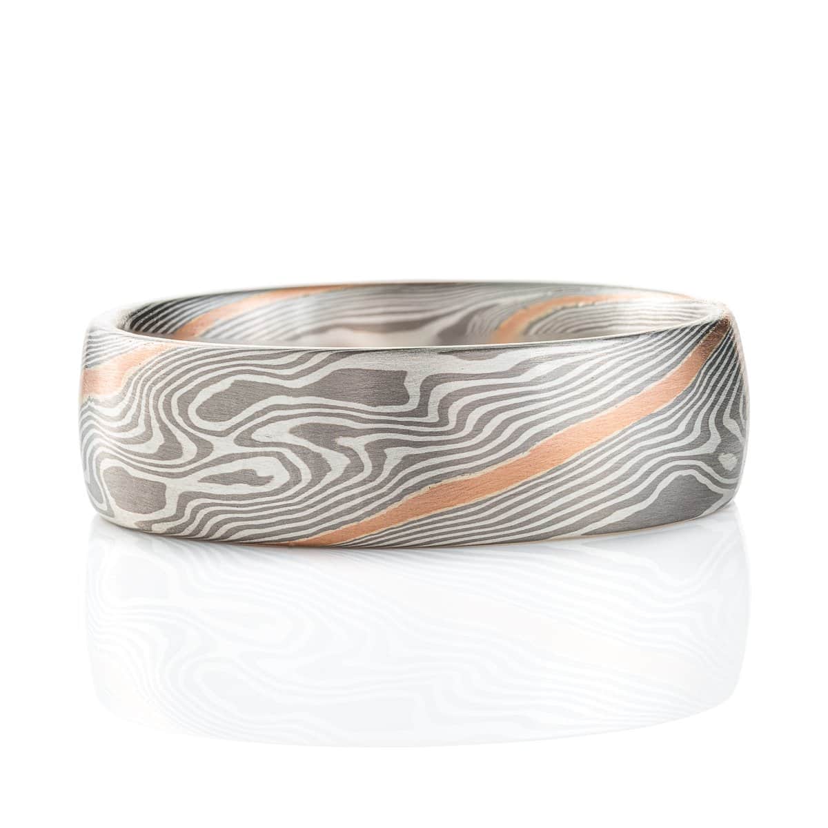 Silvery mokume gane ring made in twisting pattern, with one streak of red gold running through.