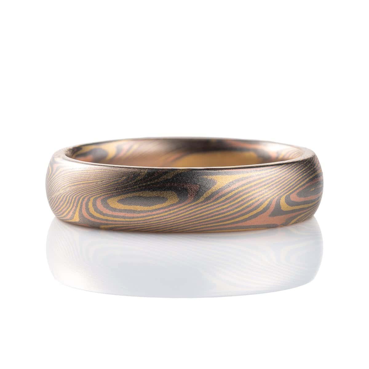 Slim mokume gane patterned ring with angled ellipse shapes running around the band, made with red gold, yellow gold and palladium, domed profile, smooth finish.