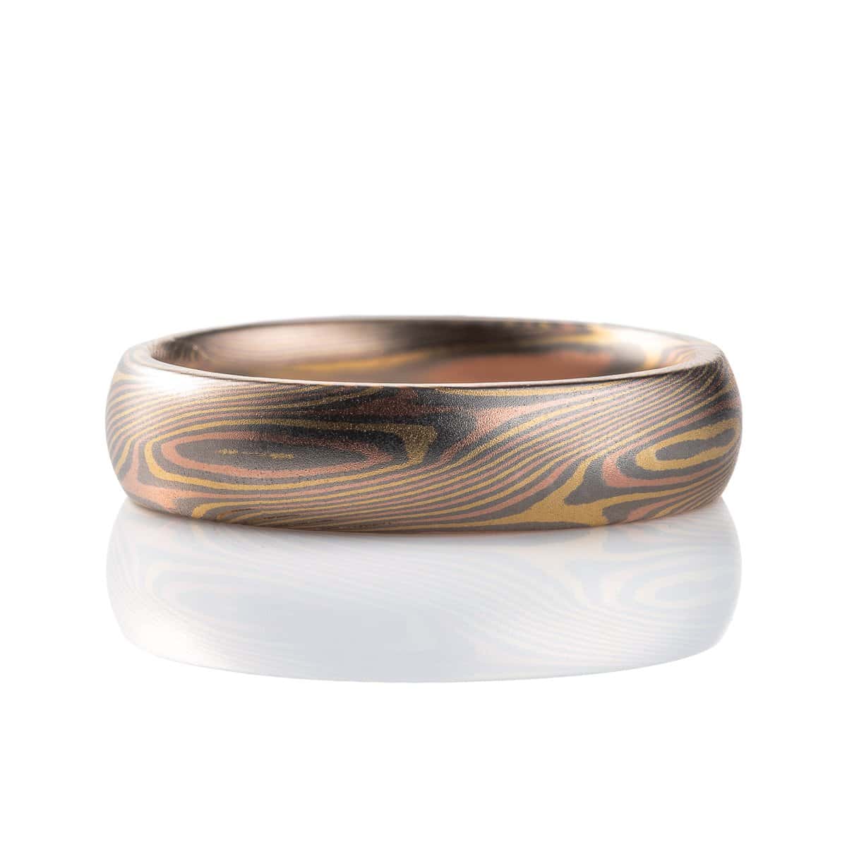 Slim mokume gane patterned ring with angled ellipse shapes running around the band, made with red gold, yellow gold and palladium, domed profile, smooth finish.