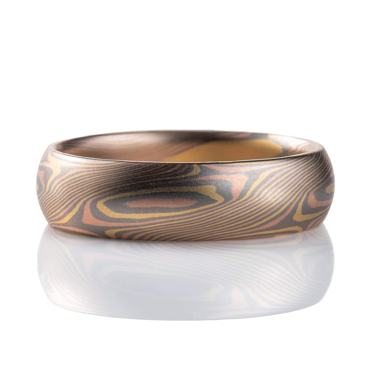 Slim mokume gane patterned ring with angled ellipse shapes running around the band, made with red gold, yellow gold and palladium, domed profile, smooth finish.