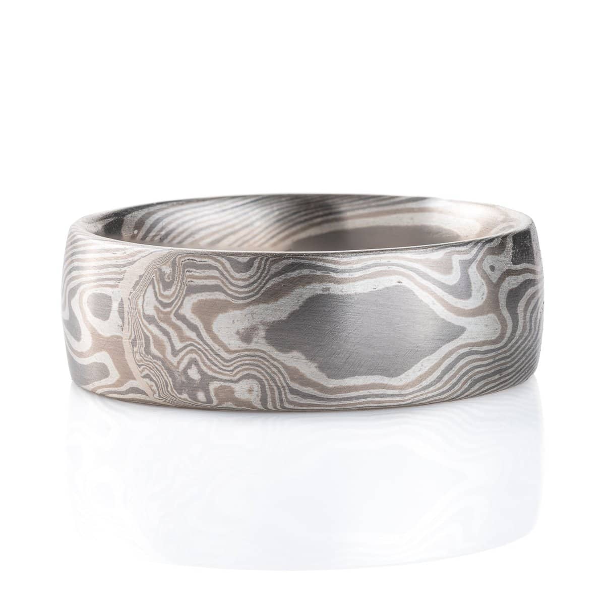 Wide, smooth finish mokume gane patterned ring, made with three different metal colors, ranging from light to dark gray.