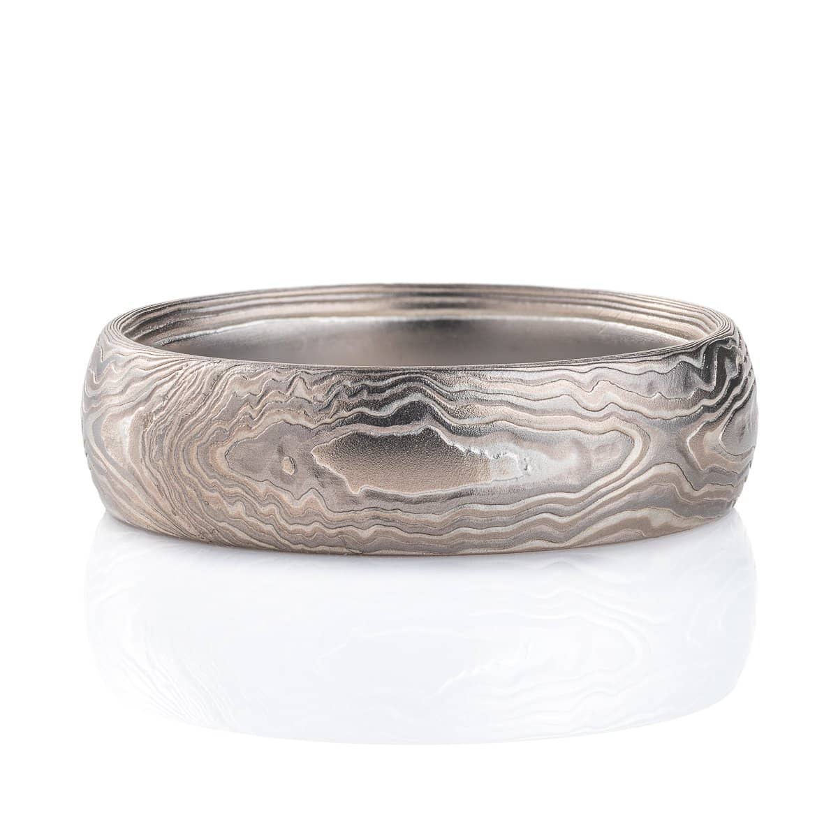 Very textured woodgrain patterned mokume gane band, made of different layers of shades of gray. Texture resembles rippling water.
