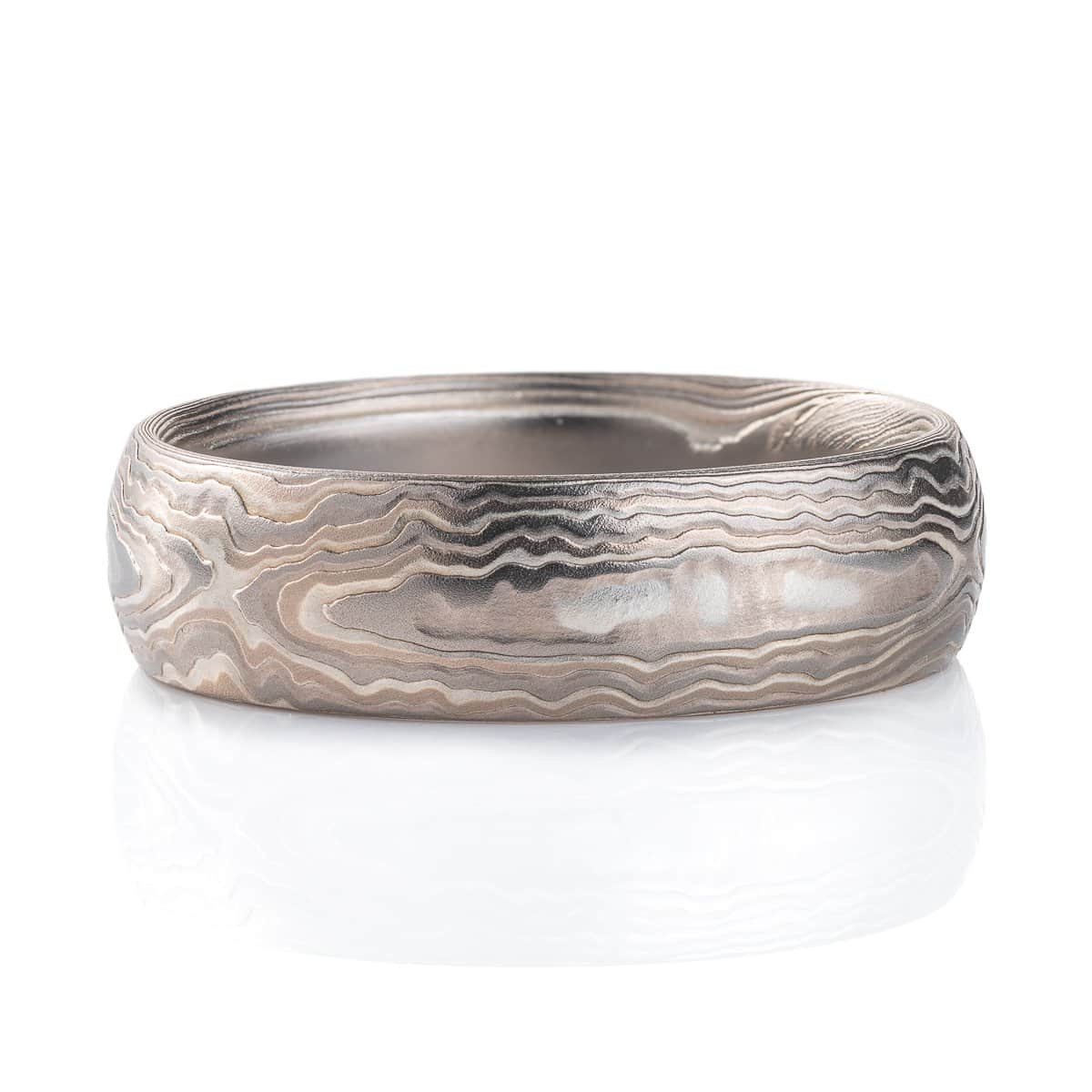 Very textured woodgrain patterned mokume gane band, made of different layers of shades of gray. Texture resembles rippling water.