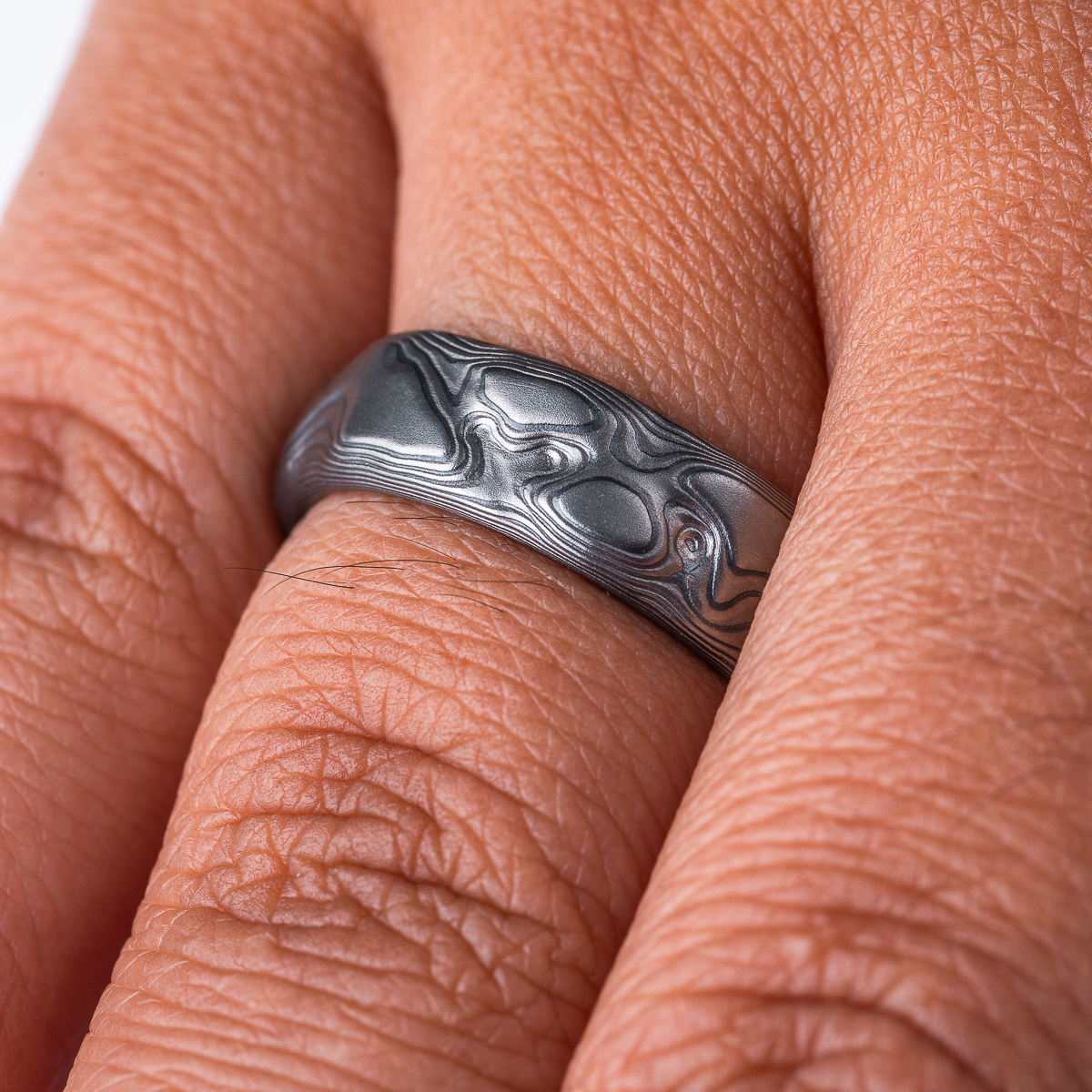 Gray and black mokume gane patterned ring, made to look like topographic/rock texture.