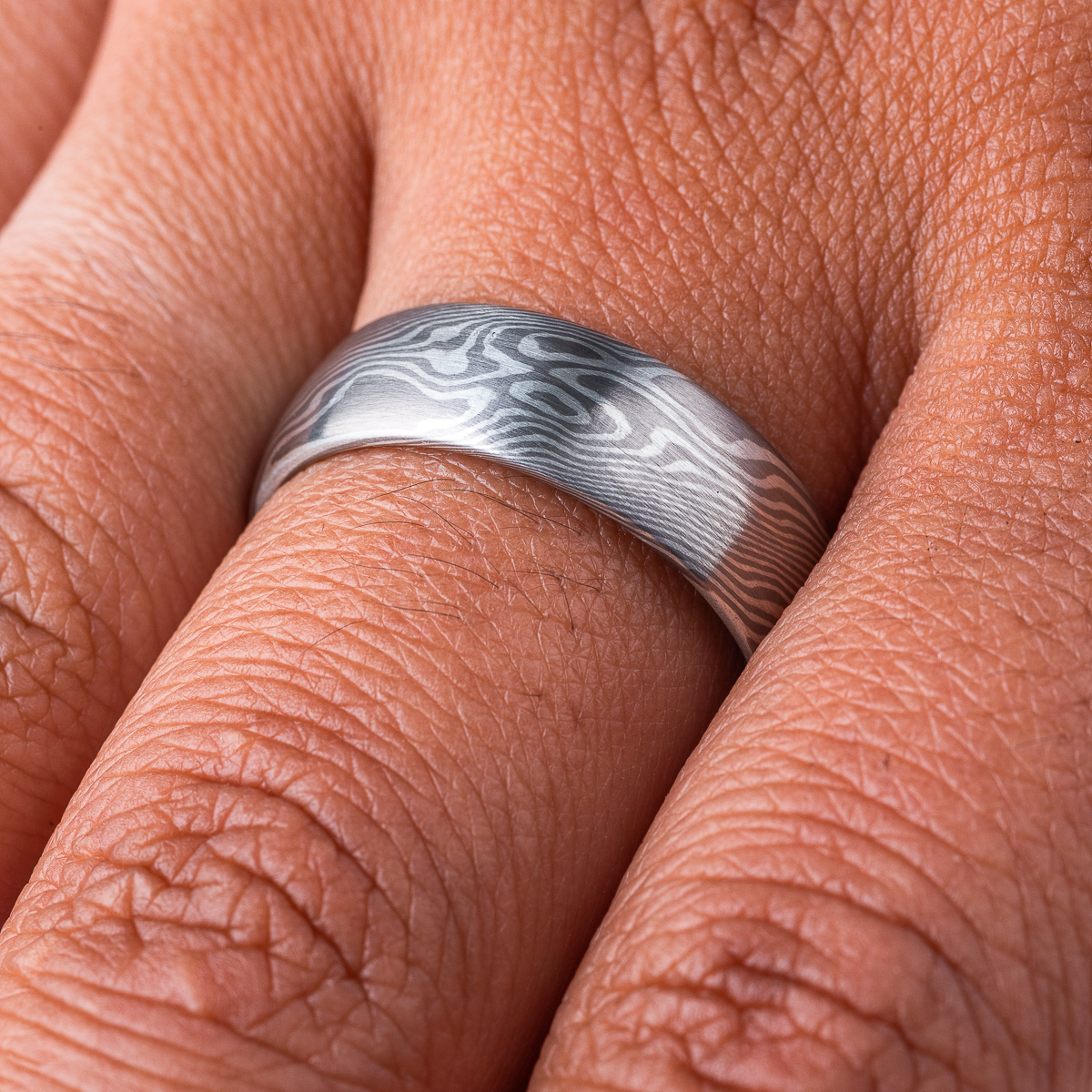 Wide mokume gane patterned ring, domed profile, made with light and dark gray metals.