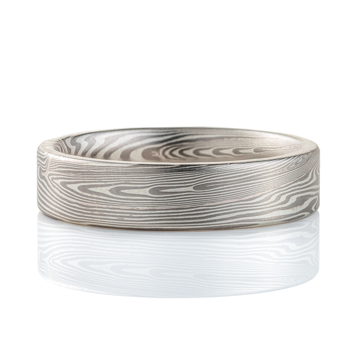 Narrow, flat profile band, mokume gane pattern in a linear style, made with palladium and silver for an overall silvery/gray color palette.
