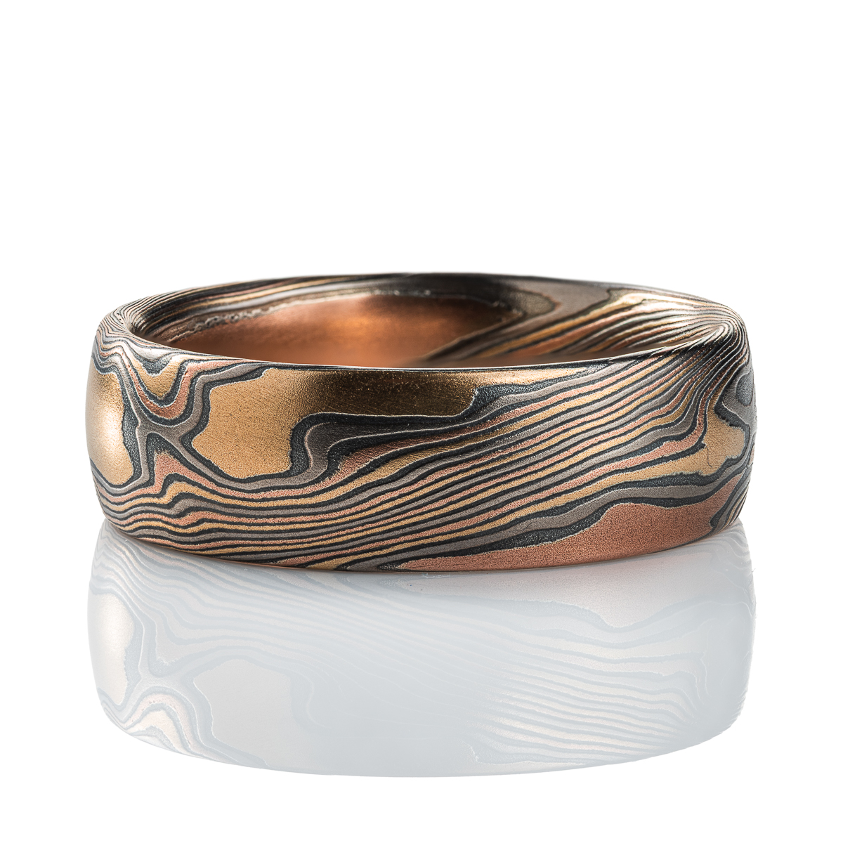 Mens mokume gane band made in twist pattern, with layers of red gold, yellow gold, palladium, and oxidized silver (black). .