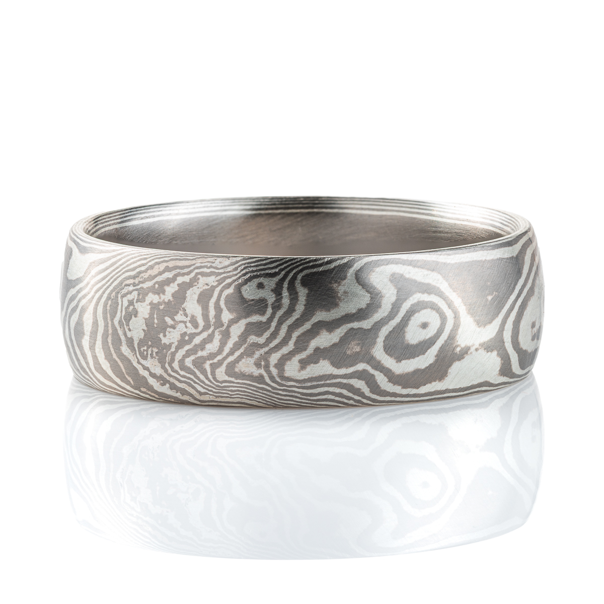Smooth, domed ring, made in a mokume gane woodgrain pattern, in a combination of palladium and sterling silver.