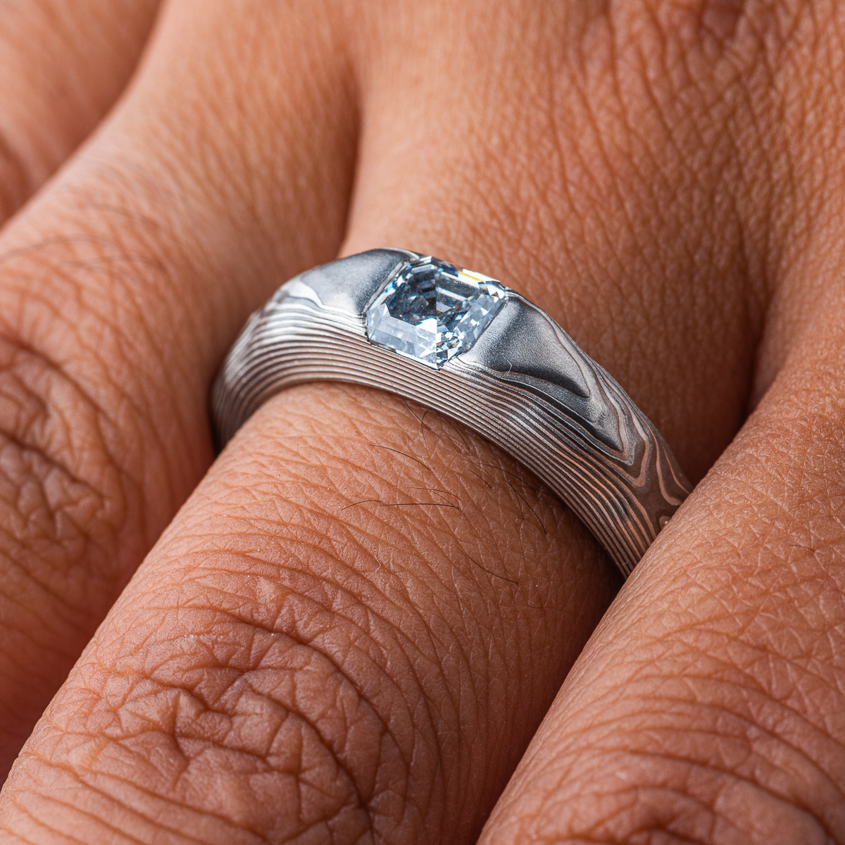 Textured mokume gane patterned ring, with three dimensional carving made to resemble rock. The ring is slightly thicker towards the top, to hold an asscher cut diamond that has been set flush into the ring.