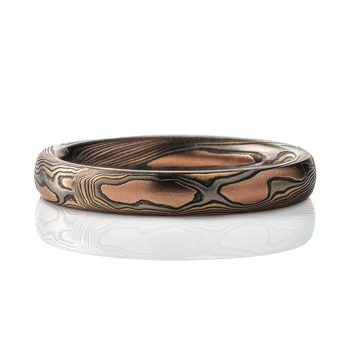 Narrow mokume gane patterned band, made with red gold, yellow gold, palladium and oxidized silver.