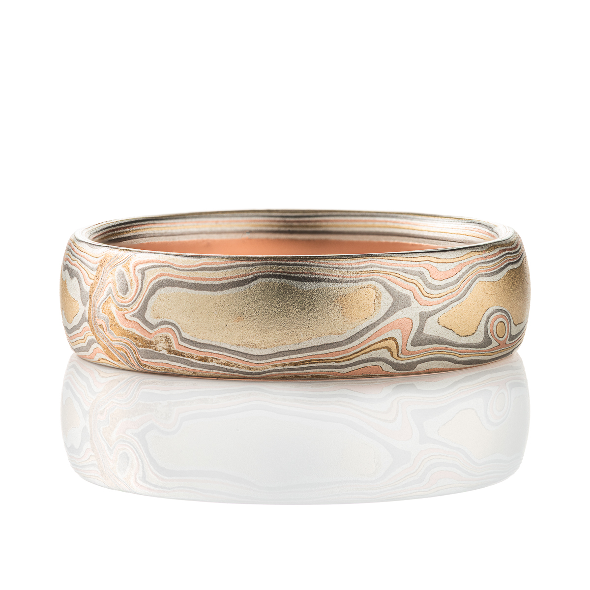 Slim mokume gane patterned band, twisting and organic flowing pattern, made with layers of red gold, yellow gold, palladium, and oxidized silver.