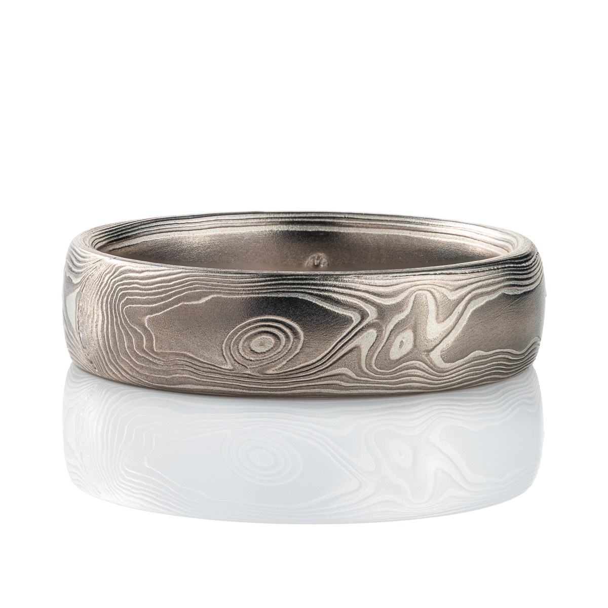 Mokume gane band patterned to resemble woodgrain, made with layers of palladium and silver.