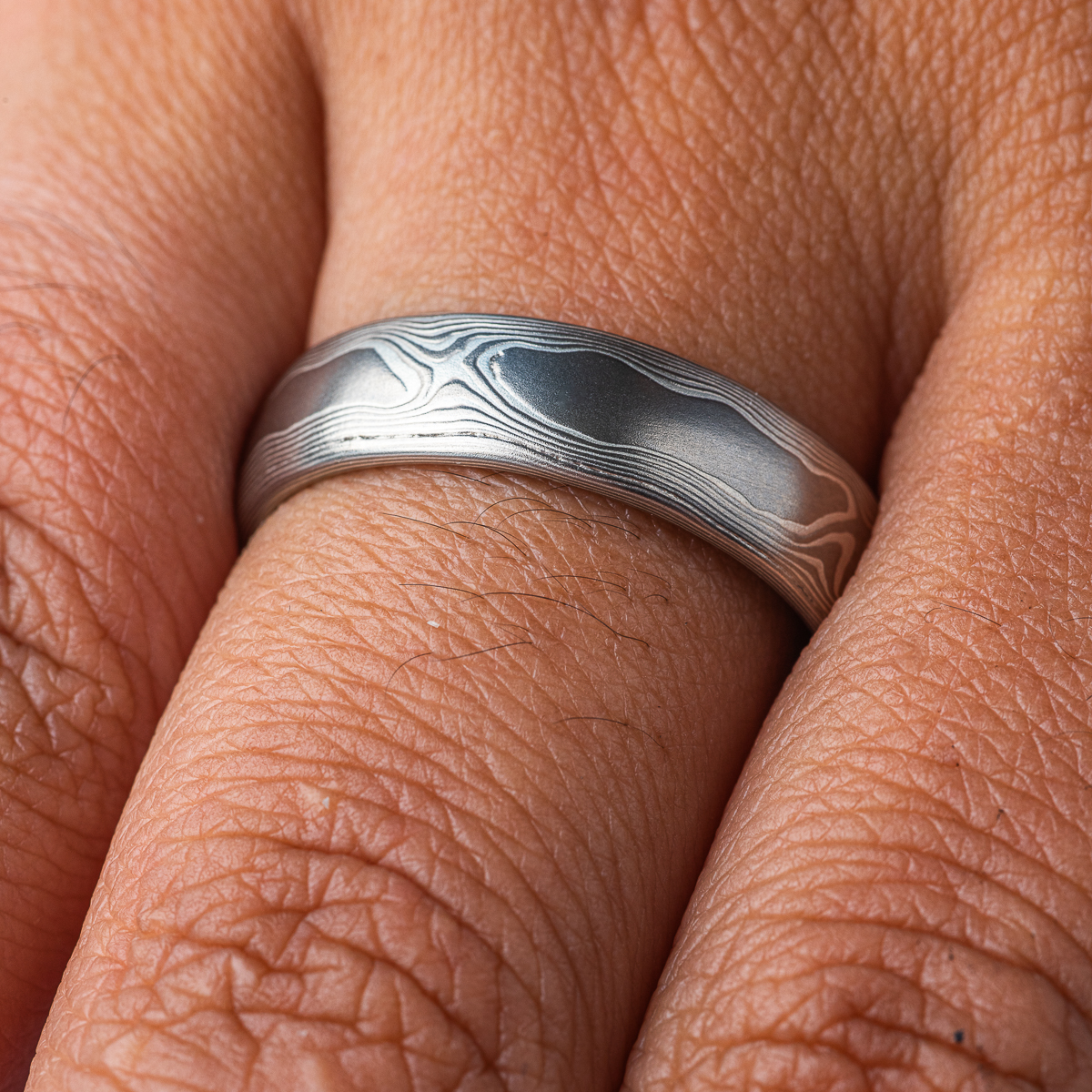 Mokume gane band patterned to resemble woodgrain, made with layers of palladium and silver.