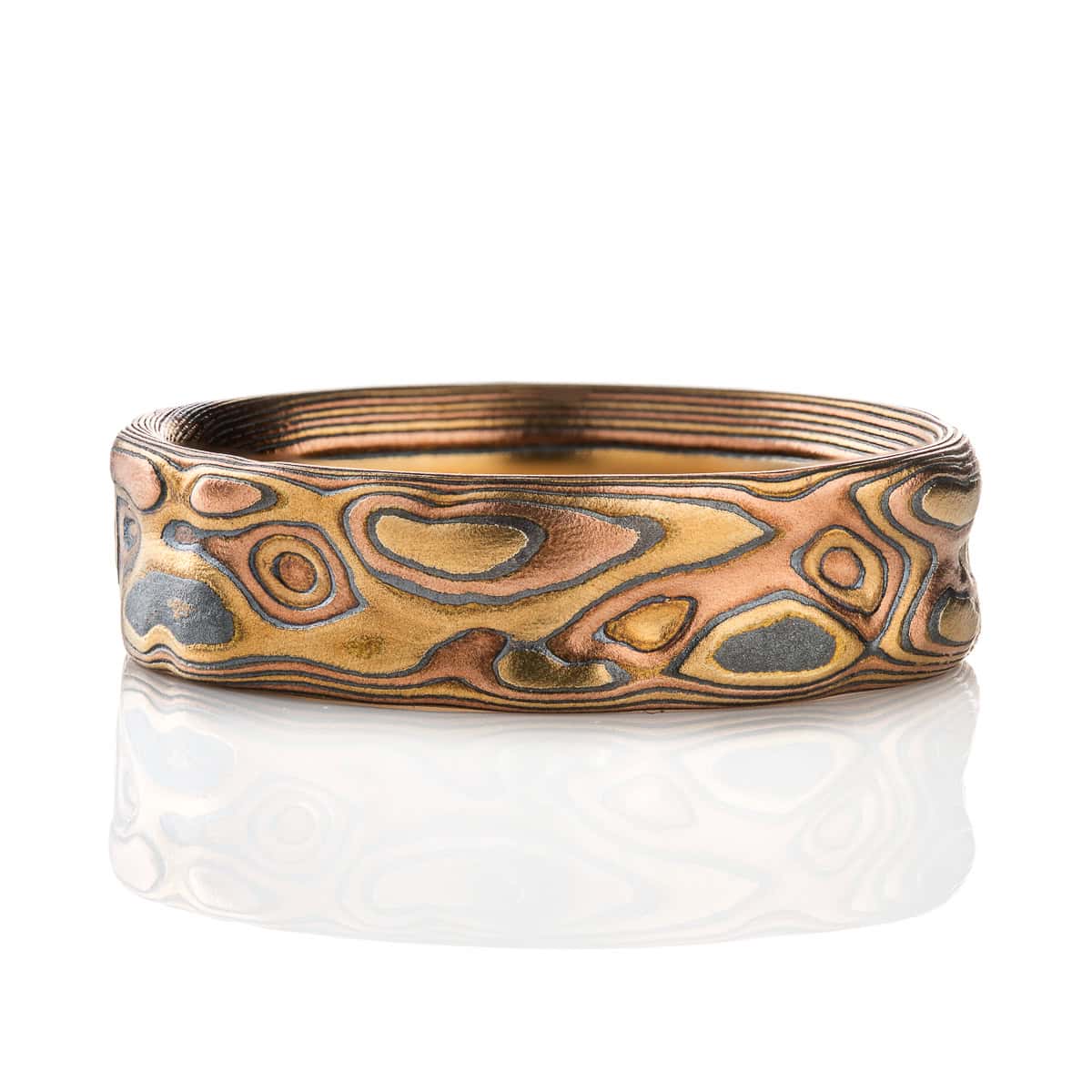 Textured mokume gane band, made with red gold, yellow gold and oxidized silver, patterned to resemble topographical maps.
